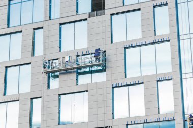 Yüksek katlı asma platform balkonu dış bina inşaatçıların insanları kamera gökdelen arka plan görünümüne geri döndürme işlemleri