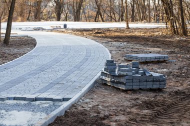 kavisli yol kaldırımı inşa etme süreci inşaat alanı toprak gri eteklerde malzeme ile çalışma alanı çevre alanı