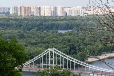 Parkın üzerinde nehir boyunca uzanan hava şehri manzarası köprüsü. Büyük bir yaşam alanı yatay arka plan manzaralı.
