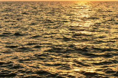 sunset dusk twilight evening lighting wavy waters sea background narrow focus perspective surface