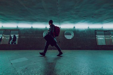 person with backpack in underground passage