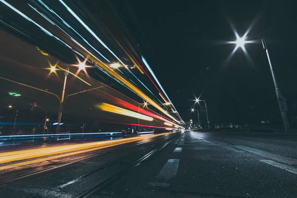 Şehir caddesinde geceleri araç ışıklı patikalar var.