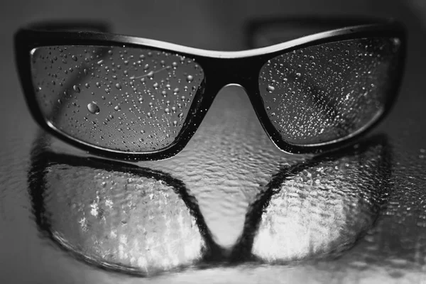 Okulary Przeciwsłoneczne Kroplami Wody Odbitymi Zwierciadle Wody — Zdjęcie stockowe