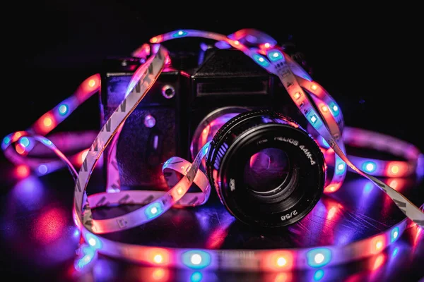 Fotoğraf makinesi renkli ışıklarla çevrili.