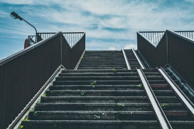 Açık havada parmaklıkları olan boş beton merdivenler.