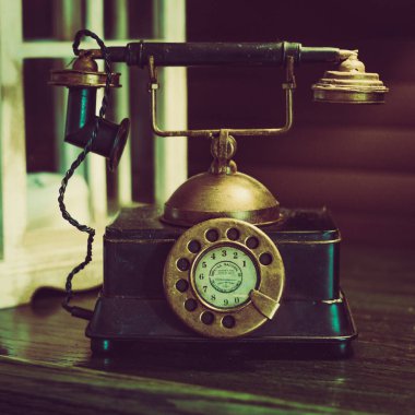 Ahşap masanın üzerindeki retro telefon.