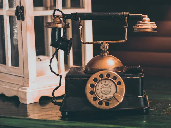 Ahşap masanın üzerindeki retro telefon.