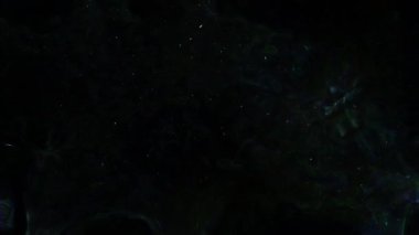 Soyut hareket arkaplanı renkli parçacıklar parlıyor. Kusursuz 4K döngü videosu.