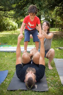 Genç bir çocuk bahçede koçlarıyla denge egzersizi yapıyor.