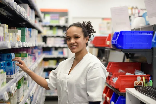 young woman pharmacist looking for a product in her shop in France