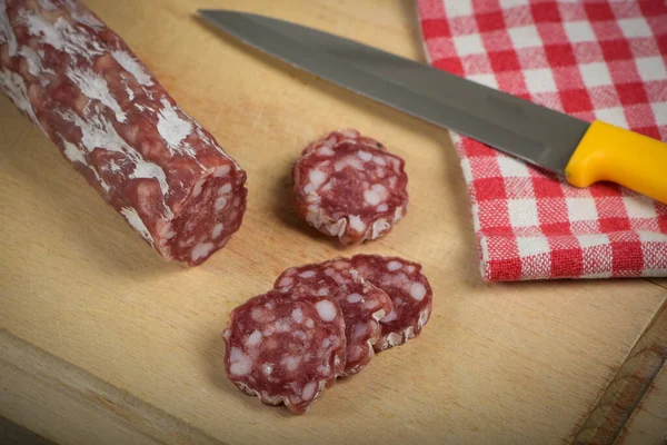 stock image view of dry sausage on cutting board on a table