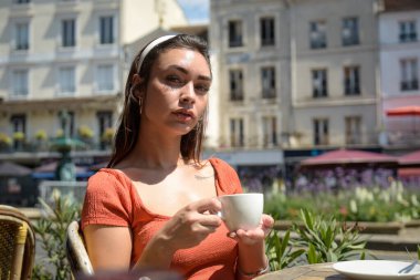 Beyaz kadın Fransa 'da bir bar terasında kahve içiyor.