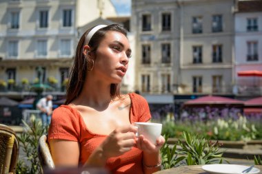 Beyaz kadın Fransa 'da bir bar terasında kahve içiyor.