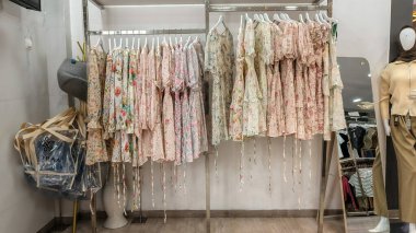 Modern moda bir butikte çeşitli renkli mütevazı elbiseler ve başörtüleri düzgün bir şekilde dizilmiş..