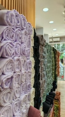 Modern moda bir butikte çeşitli renkli mütevazı elbiseler ve başörtüleri düzgün bir şekilde dizilmiş..