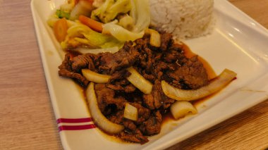 Karışık sebzeler ve buharda pişirilmiş beyaz pirinçle birlikte, içi kızarmış soğanlı sıcak bir tabak. Lezzetli ve renkli bir Asya tarzı yemek öğle veya akşam yemeği için mükemmel..