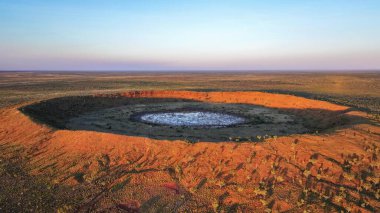 Drone photo at sunset above the second largest rimmed meteor impact crater in the world, based in remote Western Australia, clipart