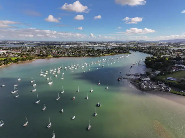 Stock image Drone shot of the Tamaki river with cloud reflections at sunset. Sailboats on moorings line up the river and marina in New Zealand