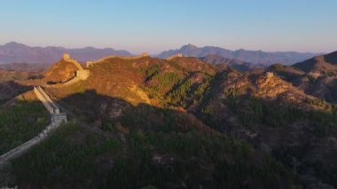 Yüksek kalite, güneş Çin Seddi 'nin kıvrımlı tepelerinden yükselirken, insan yapımı yapısal yılanlar gibi yeryüzüne yayılan 4k' lık insansız hava aracı.