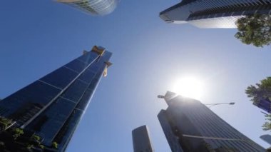 Melbourne bakış açısı POV şehir manzarası aşağıdan, uzun, heybetli bina kümülüs bulutları ve mavi gökyüzünü yansıtıyor 
