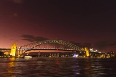 Günbatımından sonra meşhur Sydney Harbour Köprüsü 'nün gece süreleri doluyor. Kızıl gökyüzü karanlığa dönüyor. Yıldızlar ve bulutlar gökyüzünü süslerken gemiler yakınlaşıyor..