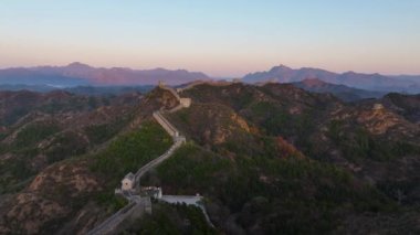 Yüksek kalite, güneş Çin Seddi 'nin kıvrımlı tepelerinden yükselirken, insan yapımı yapısal yılanlar gibi yeryüzüne yayılan 4k' lık insansız hava aracı.