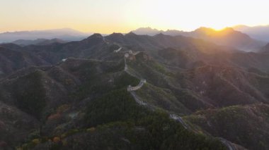 Yüksek kalite, güneş Çin Seddi 'nin kıvrımlı tepelerinden yükselirken, insan yapımı yapısal yılanlar gibi yeryüzüne yayılan 4k' lık insansız hava aracı.