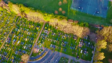 4k insansız hava aracı görüntüleri, bir mezarlığı futbol sahalarından ayıran ağaçlar, bir basketbol maçı ve kaykay parkı üzerinden geçiyor. Gün batımında Londra 'da bir yaşam diliminin yan yana gelişini gösteriyor.