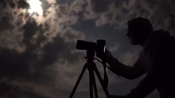 Man Shooting Night Cloudy Sky Moon Tripod — Videoclip de stoc