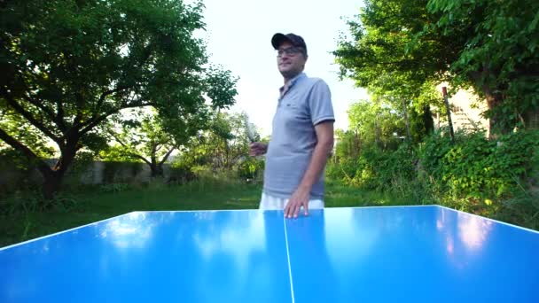 Man Glasses Cap Plays Table Tennis Outdoors — Vídeo de stock