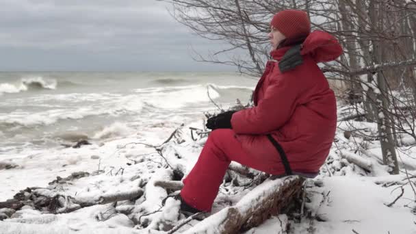 Girl Warm Red Clothes Sitting Shore Northern Stormy Sea — Vídeos de Stock