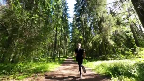 小さな女の子は夏の森の道を走っています スローモーション — ストック動画