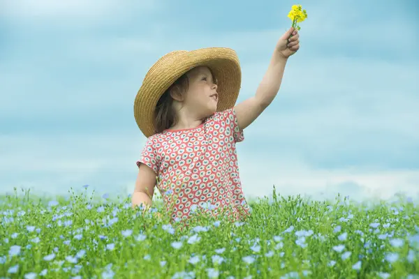 Liebenswert Lächelndes Kind Mit Strohhut Und Einem Strauß Gelber Blumen Stockbild