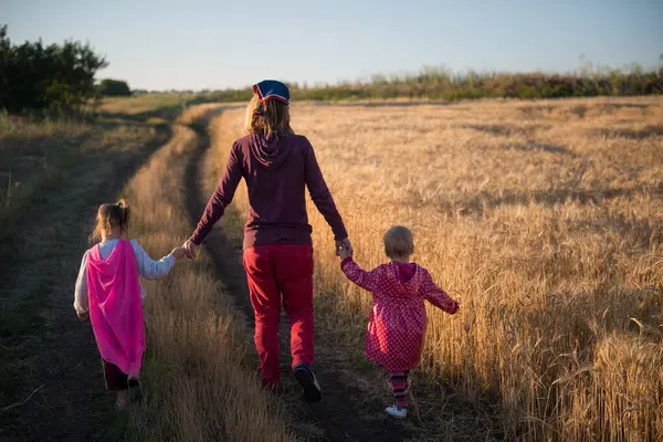 Mutter Und Zwei Kinder Gehen Auf Einer Landschaftlich Reizvollen Straße Stockfoto