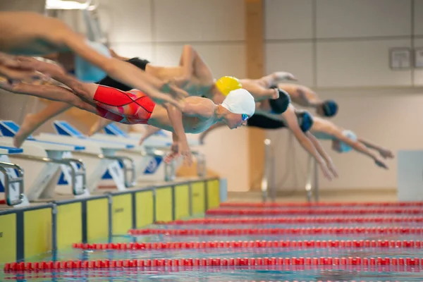 Junge Schwimmer Starten Vom Starttisch Becken lizenzfreie Stockfotos