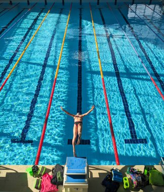 Swimmer girl start from the starting table in the pool