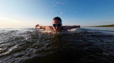 Yüzücü kız denizde kelebek gibi yüzüyor..