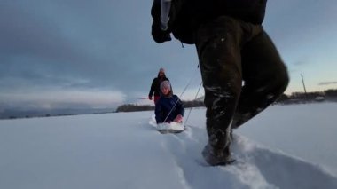Aile: Babam kızıyla birlikte kışın karda kızak çeker..