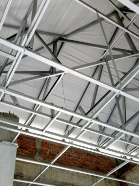 Paslanmaz çelik çatı iskeleti, binanın içinden görünen çatı inşaatı. Ev tadilatı, inşaat sahası