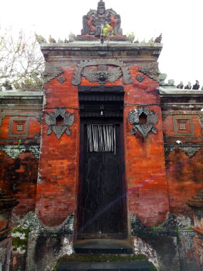 Bali 'deki Hindu tapınağı kapısı, Bali kültürünü ve din tarihini yansıtan kırmızı tuğla ve süslemeli taştan yapılmış. Eski yosunlu tuğla duvar, geleneksel yerel dilsel mimari