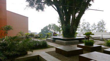 Outdoor courtyard with tree in the middle. Parahyangan Catholic university communal space. Place to gather, hang out, working space. clipart
