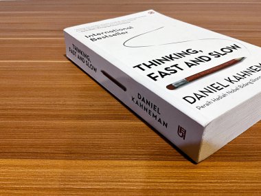 Tangerang, Endonezya - 11 Mayıs 2024 Daniel Kahneman 'ın Düşünme, Hızlı ve Yavaş kitabını ahşap bir masa üzerine kapatın.