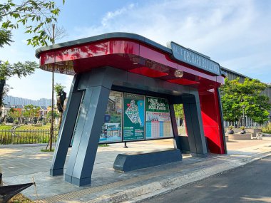 Jakarta, Indonesia - May 13, 2024: PIK 2 red bus stop with modern design shot during day time. clipart