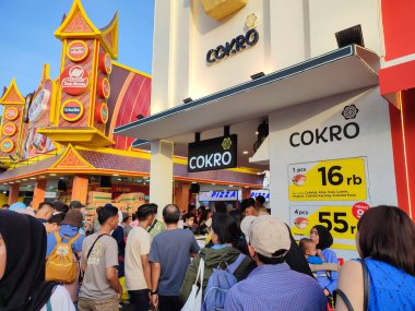 Jakarta, Indonesia - June 23, 2024: Jakarta Fair event held at Jakarta International Expo Kemayoran. Crowd waiting in line for viral Cokro brand bread clipart