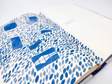 Tangerang, Endonezya - 26 Temmuz 2024: Metin ve mavi renkli resimlerle dolu açık kitap beyaz arkaplanda yakın plan görüntüsü. Görünmez Sorular Kitabı Lala Bohang önizlemesi.