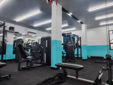 Modern spor salonunun içinde canlı çalışma alanı olan spor aletleri, kapalı alanda kas egzersizi için makine.