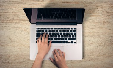 Dizüstü bilgisayarın klavyesinde yazı yazan ellerin üst görüntüsü. Ofis çalışma şablonu, iş yönetimi konsepti.