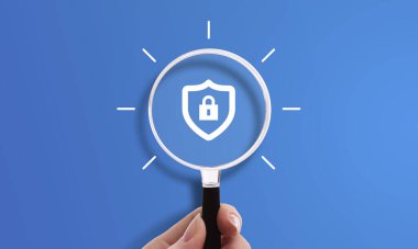 Kilitli kalkan simgesiyle el ele tutuşan büyüteç, siber güvenliğin sembolü, güvenli bağlantı ve koruma mahremiyeti. VPN logo reklamı