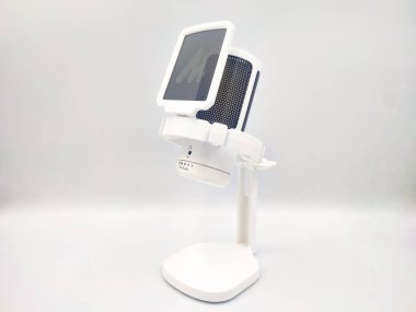 Masaüstü standında pop filtresi olan beyaz mikrofon beyaz arka planda izole edilmiş. Elektronik ürün görüntüleme için Stüdyo photoshoot, yan görünüm.