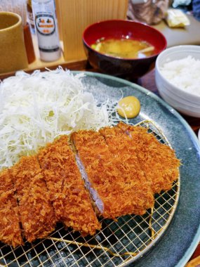 Japon domuz katsusu, doğranmış lahana, geleneksel Asya yemeği, taze garnitürle kızartılmış pirzola..